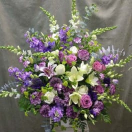 Large purple and white floral arrangement with lilies and roses