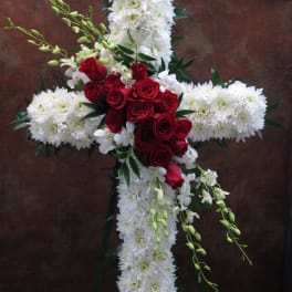 Cross-shaped floral arrangement with white blooms and red roses