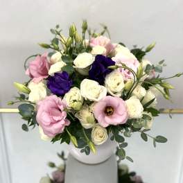 Bouquet of pink, white, and purple flowers in a white vase