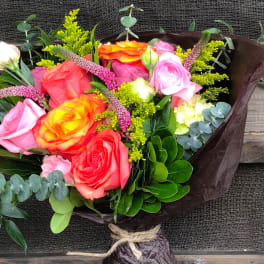 Bouquet of pink, coral, and orange roses with yellow filler flowers