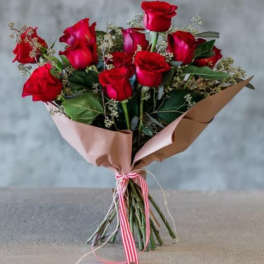 Bouquet of red roses wrapped in pink and brown paper