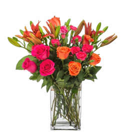 Bouquet of pink and orange roses with lilies in a clear glass vase