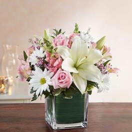 Pink and white flower arrangement in a square glass vase