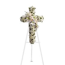White floral cross arrangement on a standing easel