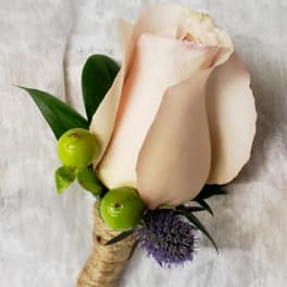 Single pale pink rose boutonniere with green berries and purple accent flower
