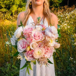 Bride holding a bouquet of blush and white roses with mixed blooms