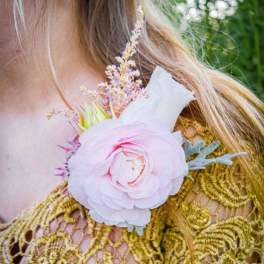Pink floral corsage with a large bloom and small accent flowers