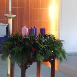 Advent wreath with purple and pink candles on a table