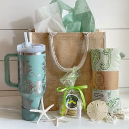 Gift basket with a tumbler, wrapped cookies, and a rolled towel