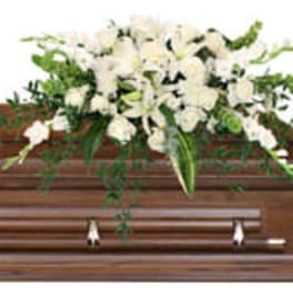 White floral spray on a wooden casket