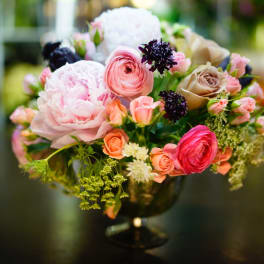 Mixed pink and cream flower arrangement in a dark vase