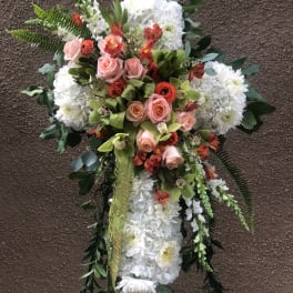 Standing floral spray with white chrysanthemums, pink roses, and orange accents