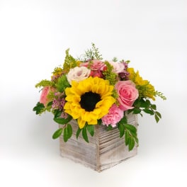 Sunflower and pink rose arrangement in a rustic wooden box