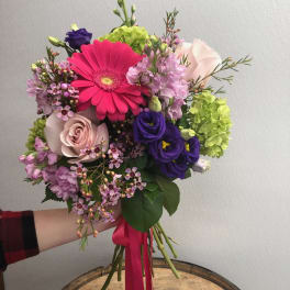 Hand-tied bouquet with pink gerbera, roses, and purple blooms