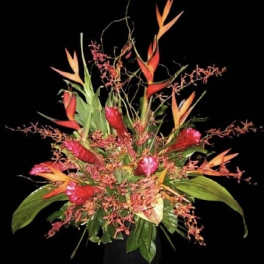 Tropical flower arrangement with red and orange blooms in a vase