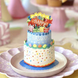 Decorative birthday cake centerpiece with colorful paper toppers