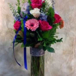 Bouquet of pink and white roses with a pink gerbera in a tall glass vase