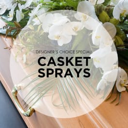 White orchid casket spray on a wooden casket