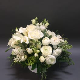 White floral arrangement in a low round container
