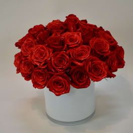 Red roses arranged in a white cylindrical vase