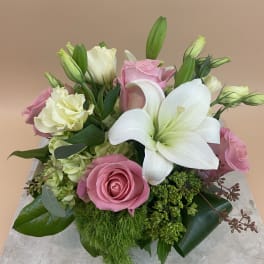 Pink roses and white lilies arranged in a low bouquet