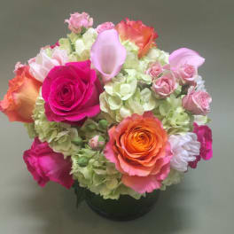 Mixed pink and orange roses with pale hydrangeas in a black vase