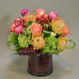 Bouquet of pink and orange flowers in a dark glass vase