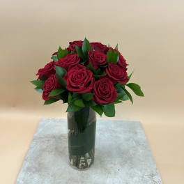 Bouquet of red roses in a tall glass vase