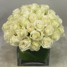 Cream rose bouquet in a square glass vase