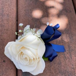 White rose boutonniere with baby's breath and a blue ribbon