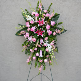 Standing floral spray with pink lilies and roses on an easel