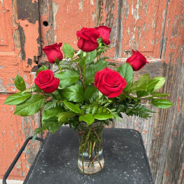 Red roses arranged in a clear glass vase