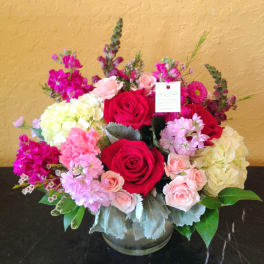 Bouquet of red and pink roses with hydrangeas in a glass vase