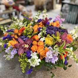 Colorful mixed bouquet with orange roses, purple orchids, and yellow accents