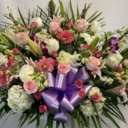 Large mixed bouquet with pink and white flowers and a purple ribbon