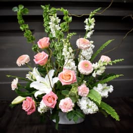 Pink roses and white lilies in a low white container