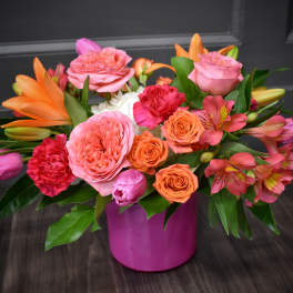 Pink and orange mixed bouquet in a magenta vase