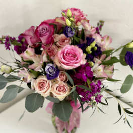 Pink and purple rose bouquet in a glass vase