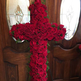 Cross-shaped arrangement of red roses on a stand