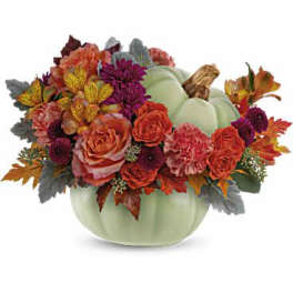 Autumn floral arrangement in a pale green pumpkin vase