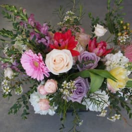 Mixed bouquet with roses, tulips, and gerbera daisies in pink, white, purple, and yellow