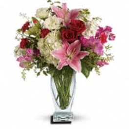 Pink lilies and red roses in a clear glass vase