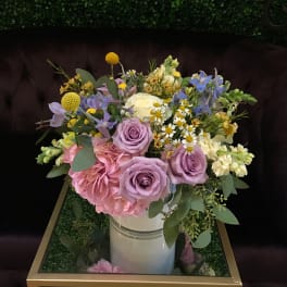 Bouquet of pastel roses, hydrangea, and small daisies in a white vase