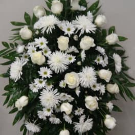 White floral funeral spray with roses and daisy-like blooms