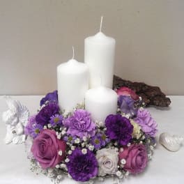 Purple floral candle centerpiece with three white pillar candles