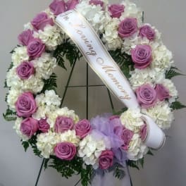 Pink rose and white hydrangea funeral wreath with a memorial ribbon
