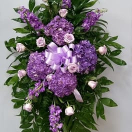 Purple floral standing spray with roses and hydrangeas on a ribboned easel