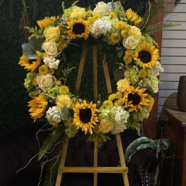 Sunflower and white rose wreath on a wooden easel