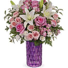 Pink and white flower bouquet in a purple vase