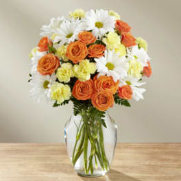 Orange roses and white daisies in a clear glass vase